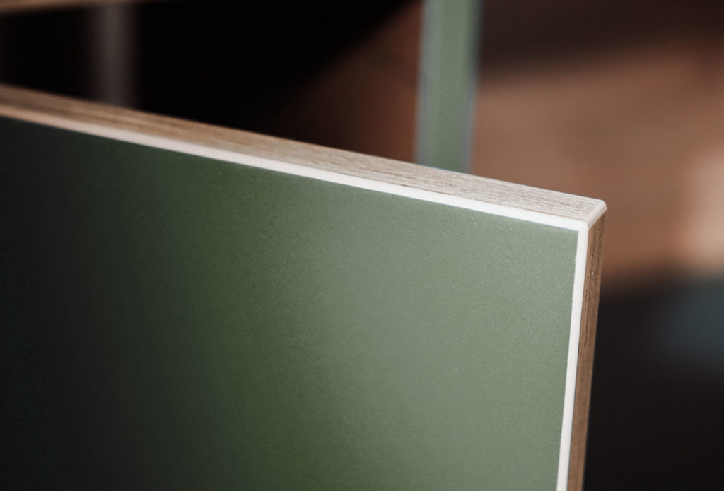 Gros plan sur une étagère modulable Hecko en bois, finition vert mat avec chant clair apparent